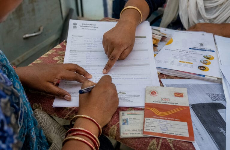 Woman filling government form with bank passbook nearby