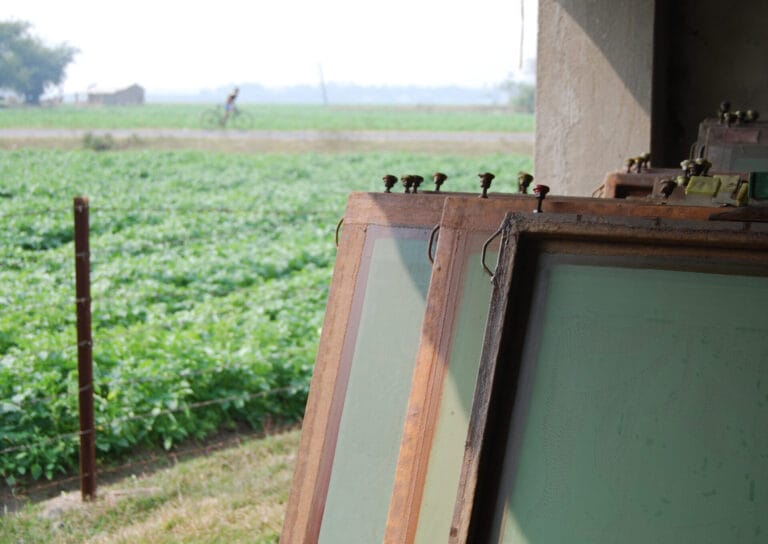 Wooden screen printing frames beside green farmland